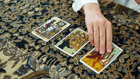 A woman giving a tarot reading with death the seven of cups and the six of wands cards