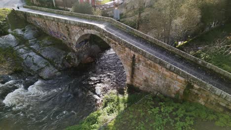 drone desciende en un puente triangular bajo la luz de la madrugada en el río lonia ourense españa