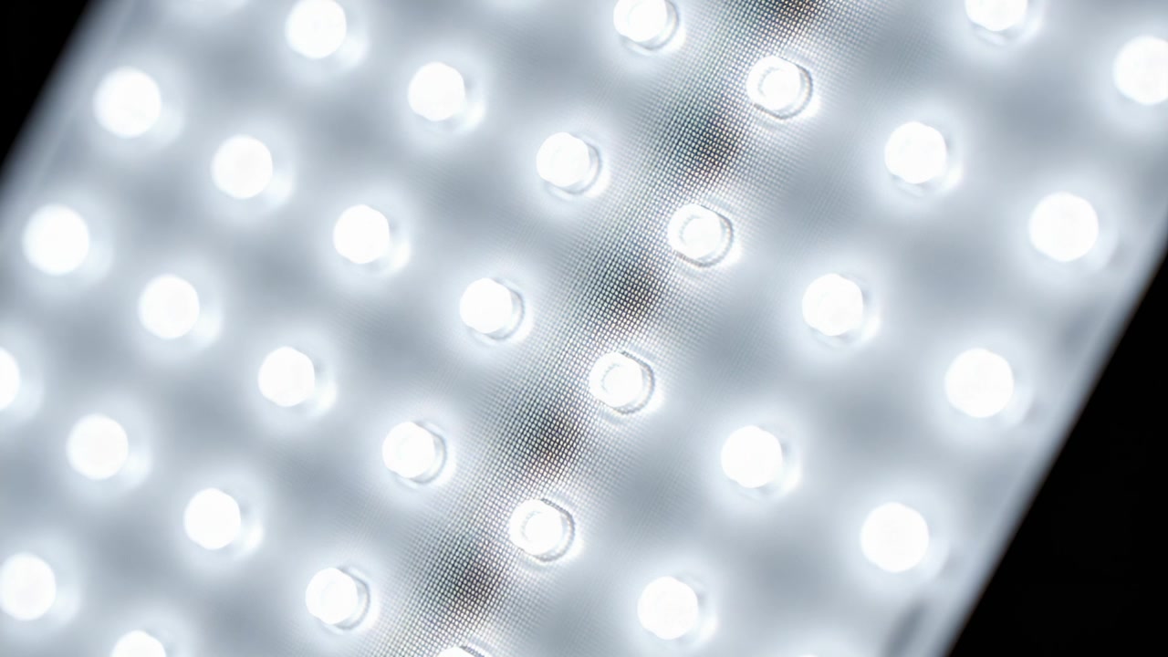 Starting camera tilt, LED panel emitting steady glow in studio, showcasing textured diffuser