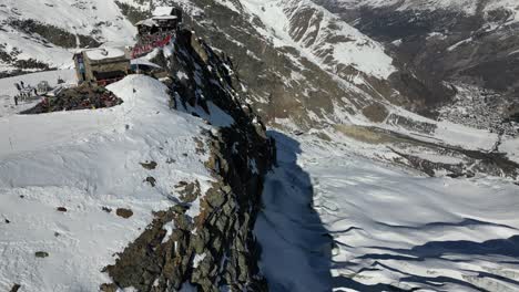 vista aérea de una pista de esquí en los alpes suizos junto a una fachada rocosa, saas fee