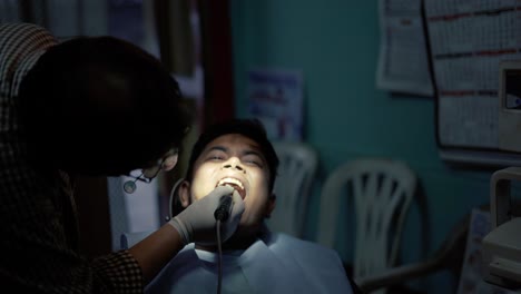 a dentist treating a patient with oral prophylaxis process