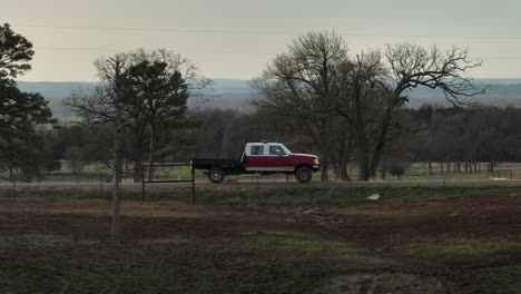 truck side view driving through the country past farms and trees during the late afternoon in slow motion