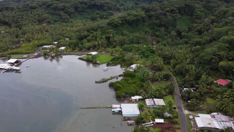 narrow coastal road follows shallow south seas bay, lush tropical isle