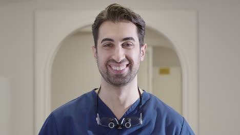 frontal view of smiling healthcare professional making eye contact at workplace