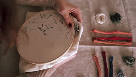 crop faceless woman doing embroidery with hoop at home