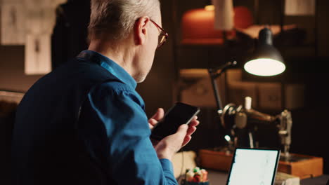 Male-tailor-using-devices-in-atelier