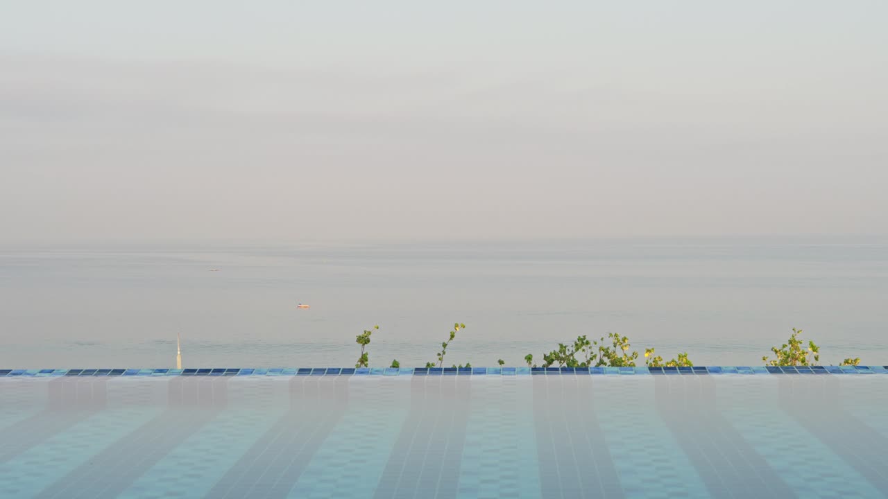 해가 뜨면서 바다를 내려다보는 경치 좋은 옥상 호텔 수영장