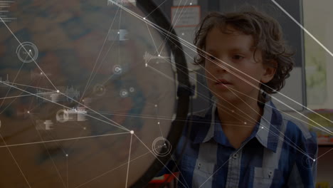 animation of network of connections with icons over caucasian boy with globe at school