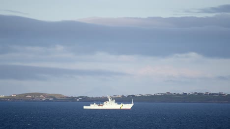 a navy coastguard fisheries protection vessel drives through rough seas