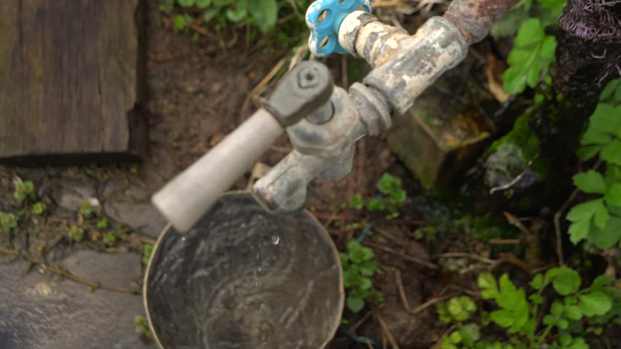 L'acqua dal rubinetto gocciola nella vecchia casseruola 02