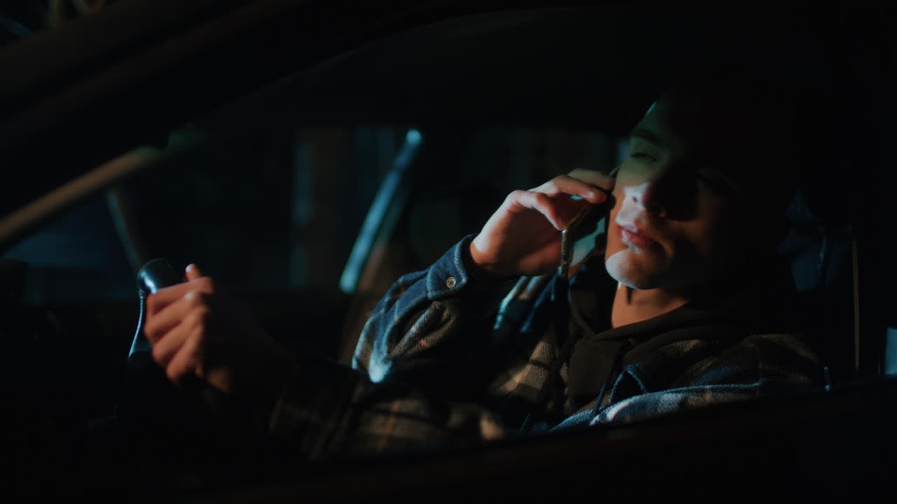 Person Driving a Car at Night Talking on a Phone