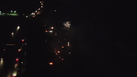 aerial view of fireworks and fires on a beach at night