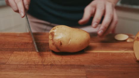 el chef corta los lados de las papas para preparar papas fritas gruesas