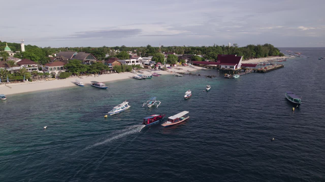 Aerial view tracking a boat on the coast of Gili Trawangan, Indonesia, sunrise