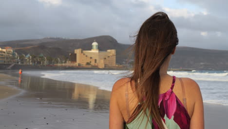 Plano-Cinematográfico-De-Una-Mujer-Admirando-El-Auditorio-Alfredo-Kraus-Desde-La-Playa-De-Las-Canteras,-En-La-Isla-De-Gran-Canaria