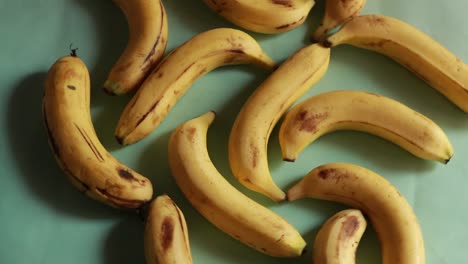 a macro shot of ripe yellow organic bananas rotating against a green background