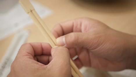 selektive fokussieransicht zur hand, während essstäbchen vorbereitet werden