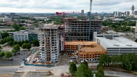 slowly rising drone shot of apartment building under construction next to newly built parking garage