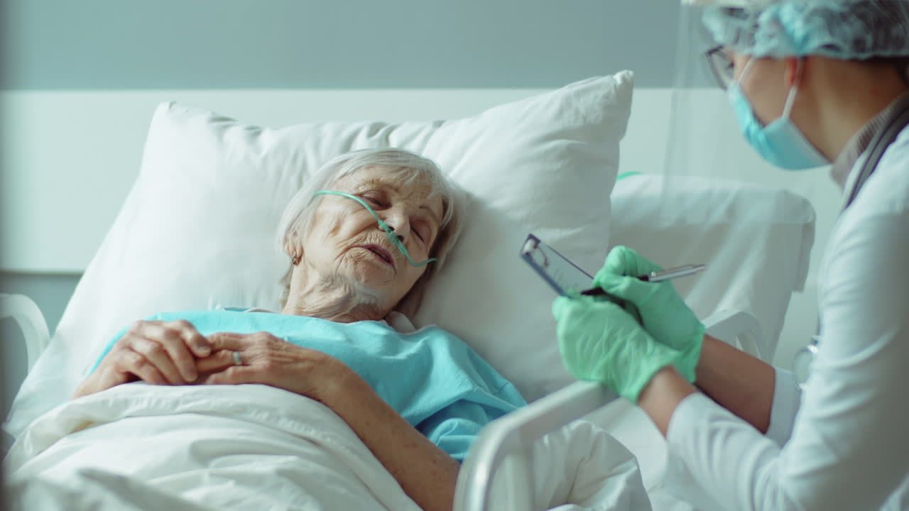 una mujer mayor hablando con un médico en uniforme de protección.