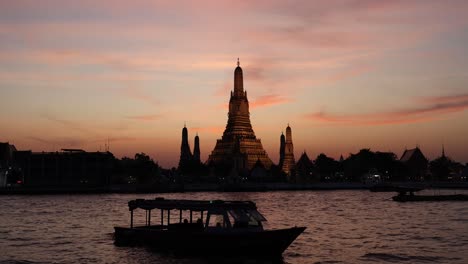 time-lapse of boats passing by wat arun at sunset