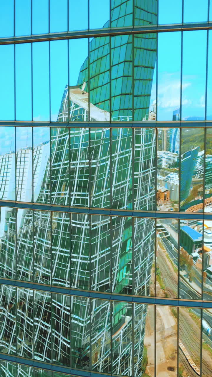 Fachada de Edifício Moderno de Vidro Refletindo a Paisagem Urbana