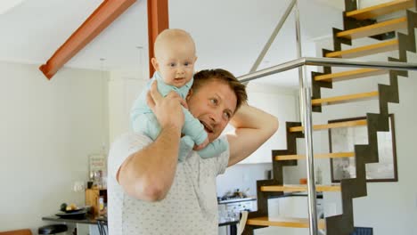 father playing with his baby boy at home 4k