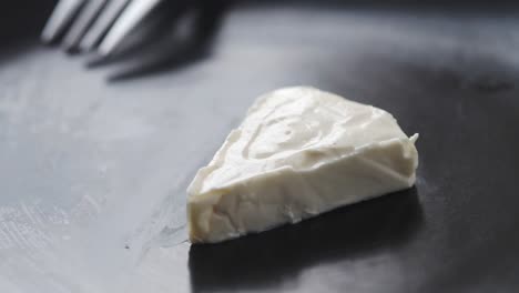 triangle of cheese on a dark plate