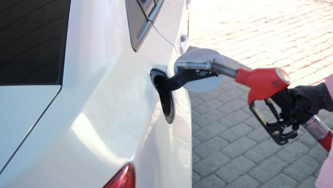 primer plano de una mujer abasteciendo de combustible en una gasolinera