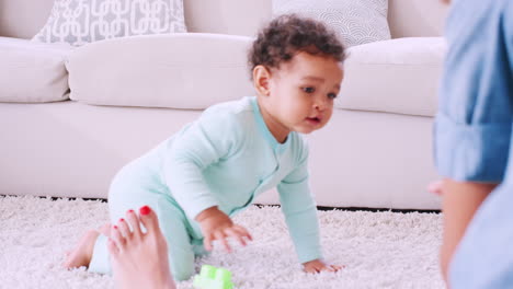 black toddler boy crawling to his mother in sitting room