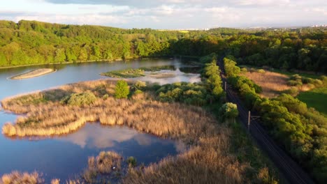 aerial view of a tranquil lake with a train passing by
