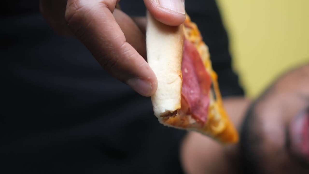 persona comiendo una rebanada de pizza