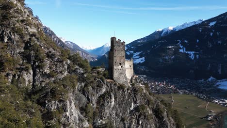 an old ruin of a castle on a rock in the mountains in winter