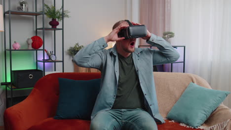 Adult-man-use-virtual-reality-headset-glasses-at-home,-enjoying-video-concept-moving-hands-in-air