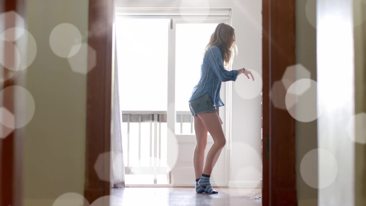 행복한 백인 십대 소녀가 집에서 춤을 추는 빛의 점의 애니메이션