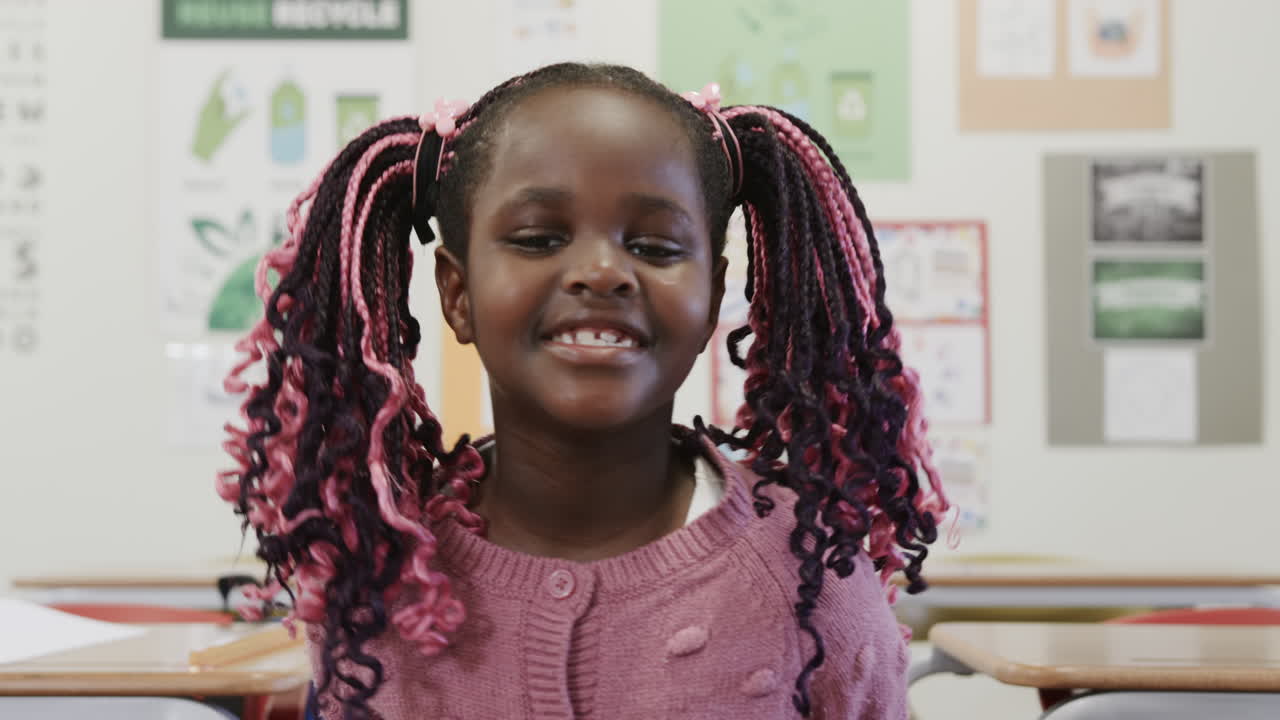 Smiling African American girl in classroom with colorful braids, feeling happy, at school