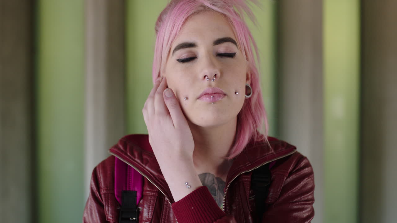 retrato de una mujer joven excéntrica de cabello rosa con aspecto punk alternativo