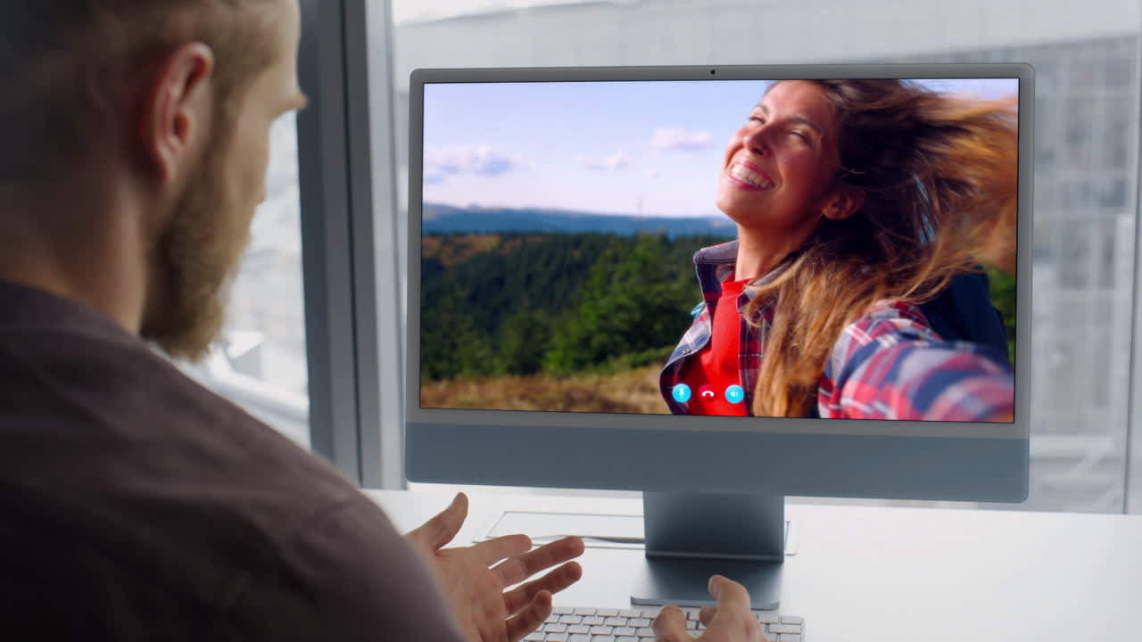 Primo piano di uomo barbuto che parla durante una videoconferenza al PC a casa. Ragazzo che chiama una donna