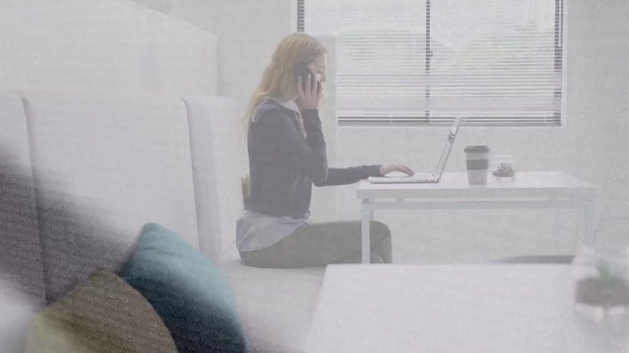 Donna che tocca il telefono, con un'icona di chiamata animata che appare, che risponde mentre digita sul laptop per lavoro d'ufficio.