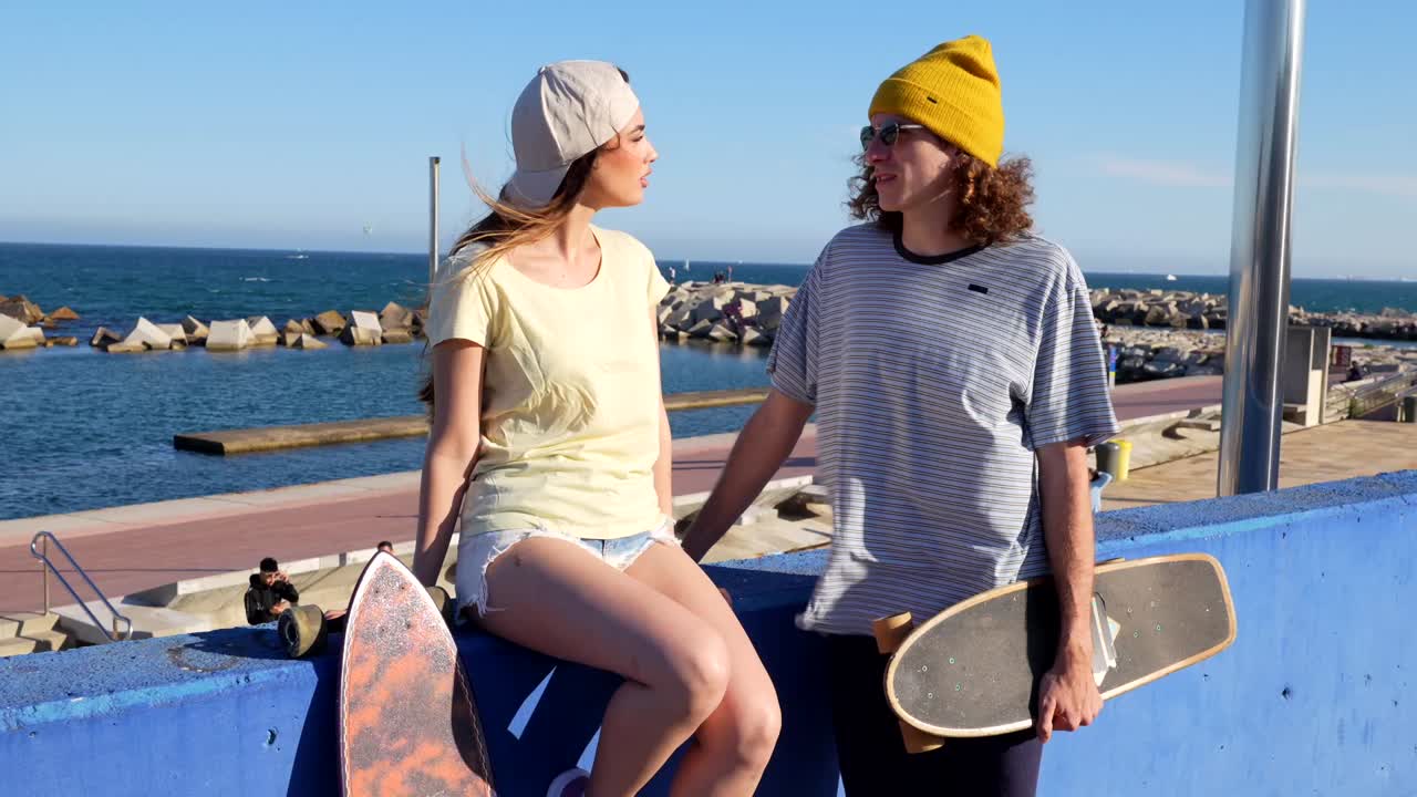 Couple with skateboards at the beach