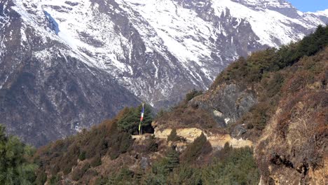 una vista de un sendero de montaña y una bandera de oración en las montañas del himalaya en el sendero del campamento base del everest