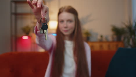 child girl real estate agent showing the keys of new home house apartment buying or renting property