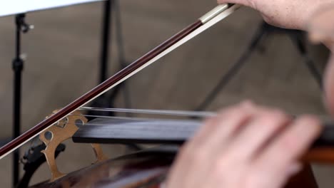 close-up of a bow with strings of a cello, professional cellist plays