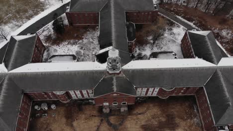 drone shot revealing the huge scale of a large decaying building at the abandoned fairfield hills hospital asylum in newtown, connecticut