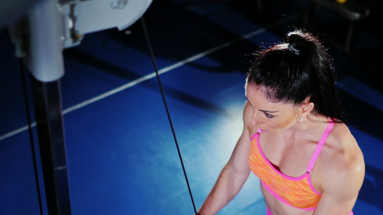 mujer atlética fuerte entrenando en el gimnasio vista desde arriba