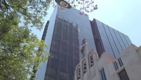 view from a vehicle of a large modern glass building on a famous avenue in mexico city