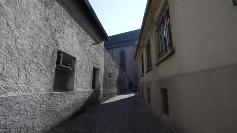 gobblestone small street leading to the catholic church of saint joseph in colmar, france