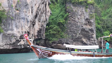 boat travels past lush, rocky island scenery