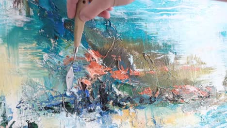 hand of a painter painting a picture with blue paints close up of a professional artist's tool - hand of a painter painting a picture with blue paints, close up of a professional artist’s tool. slow shooting 240 frames per second