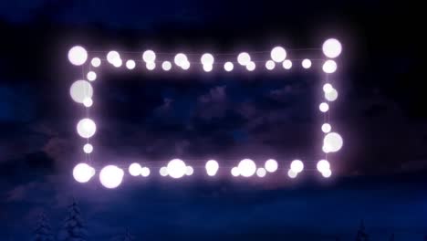 animation of fairy light frame with copy space over fir trees and winter scenery