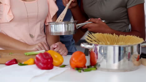 three friends cooking a tasty meal with vegetables